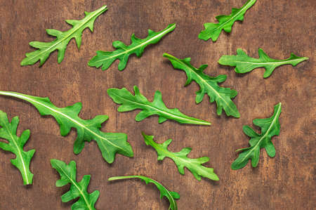 Ruccola leaf on wooden table, fresh green arugula leaves collection top view.の写真素材