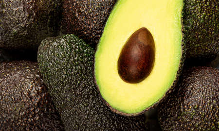 Fresh avocado as a background. Black Haas avocado closeup. food wallpaper