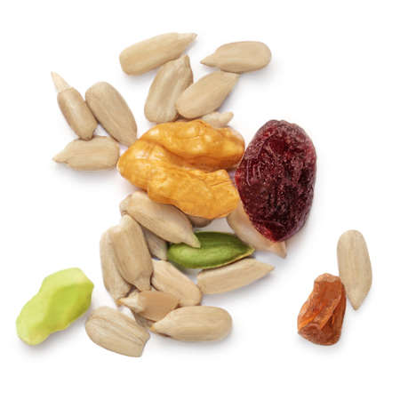 Heap of nuts and seeds isolated over the white background. Creative layout made of cereal mix, with dried fruits and seeds.の写真素材