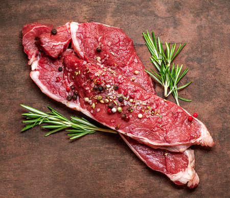 Fresh raw beef steak meat on old wooden table.の写真素材