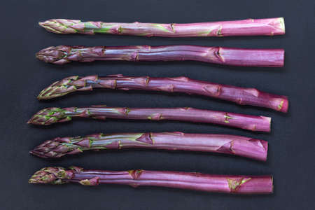 Asparagus. Fresh purple asparagus on black slate background. top viewの写真素材