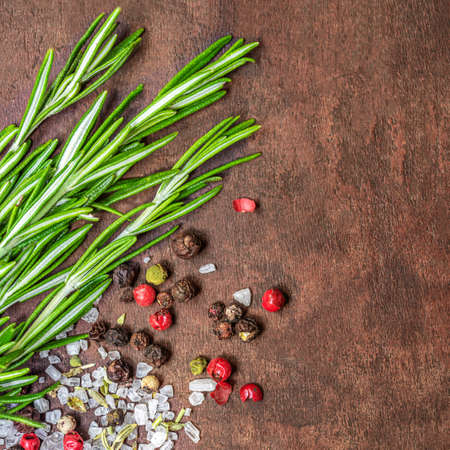 Fresh Rosemary herb on the dark wooden background. Top view rosemary bound with spices and sea saltの写真素材