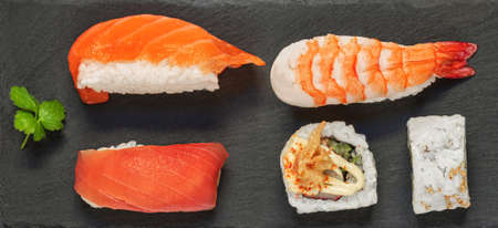 Sushi rolls set an a black slate background. Japanese restaurant menu. Sushi with salmon, tuna and avocado. top view. flat layの写真素材