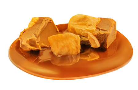 Caramel candies with sauce isolated on a white background close up. Crushed caramel piecesの写真素材