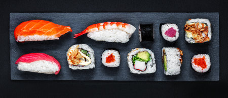 Sushi set on a black slate background. Japanese restaurant menu. Sushi with salmon, tuna and avocado. top view.の写真素材