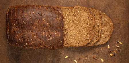 Top view of sliced wholegrain bread on dark ructic wooden background closeup. top viewの写真素材
