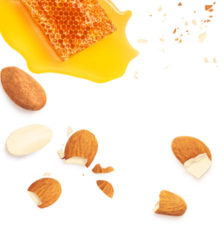 Creative layout made of honey, honeycomb and almond nuts isolated on white background. Honey syrup Flat lay. pattern. food concept.の写真素材