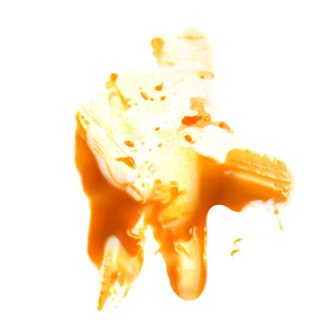 Liquid sweet melted caramel splash isolated on a white background. Toffee caramel sauce or maple syrup swirl top view. flat layの写真素材