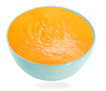 Blue Bowl of squash soup isolated on a white background. Autumn pumpkin cream-soup closeupの写真素材