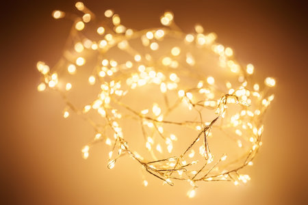 Christmas golden lights background. Abstract twinkled bright bokeh defocused lightsの写真素材