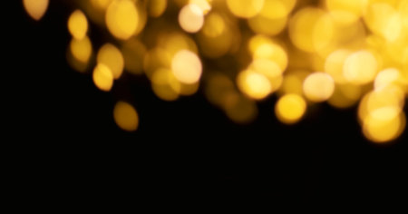 Christmas golden lights background. Abstract twinkled bright bokeh defocused lightsの写真素材