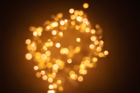 Christmas golden lights background. Abstract twinkled bright bokeh defocused lightsの写真素材