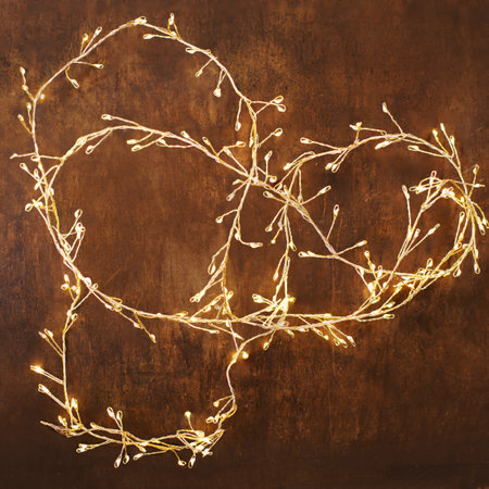 Christmas lights on a dark wooden background. Golden Xmas decorations sparkling garland top view, copyspaceの写真素材