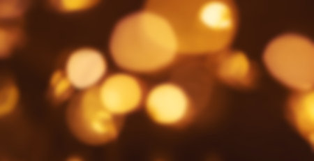 Christmas golden lights background. Abstract twinkled bright bokeh defocused lightsの写真素材