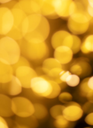 Christmas golden lights background. Abstract twinkled bright bokeh defocused lightsの写真素材