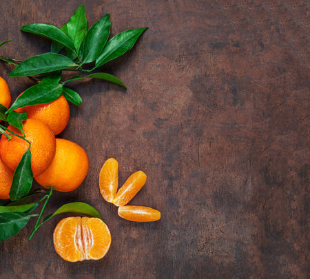 Fresh mandarin oranges fruit or tangerines with leaves on rustic wooden table, top view. Flat lay. Copyspaceの写真素材