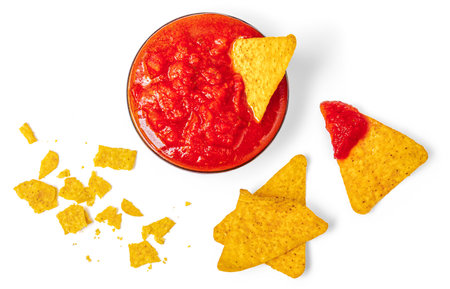 Nachos chips with salsa sauce isolated on white background. Salty chips and crumbs Top view. Flat lay.の写真素材
