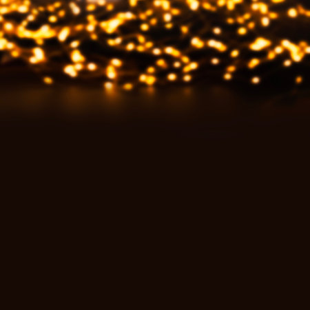 Christmas bokeh lights on a dark background. Gold de-focused garland lights
