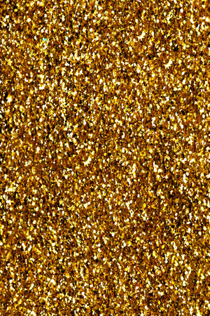 Gold glitter texture sparkling shiny background for Christmas card. Twinkly golden glitter lights grunge backgroundの写真素材