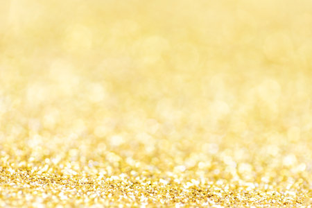 Golden lights Abstract Christmas background. Magic shining gold dust. Holiday New year Glitter Defocused Backgroundの写真素材