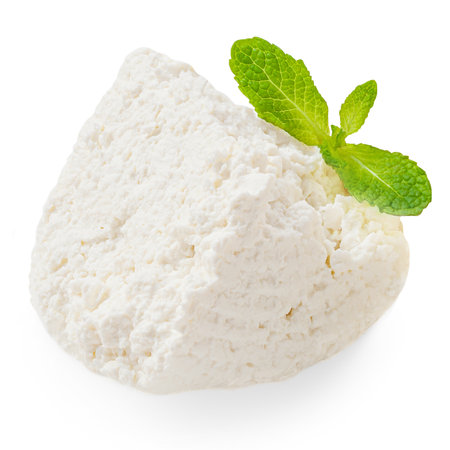 Cottage cheese isolated on white background closeup. Fresh grainy cottage cheese or feta with mint leaf close upの写真素材