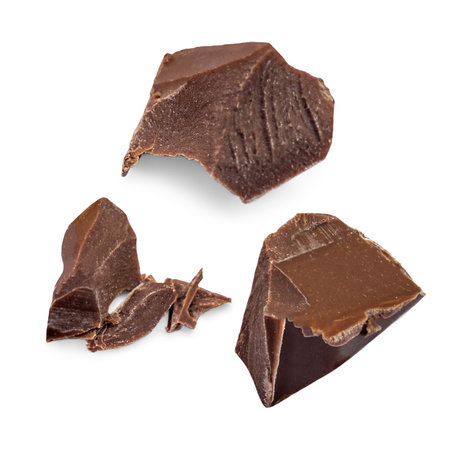 Broken milk chocolate pieces isolated. Dark Chocolate pieces with crumbs on white background as package design elements. Top view. Flat layの写真素材