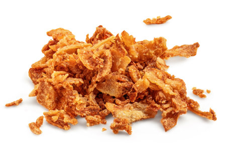 Pile of crispy fried onions isolated on white. Roasted Onions. Scattered Dry Onion Pieces closeupの写真素材