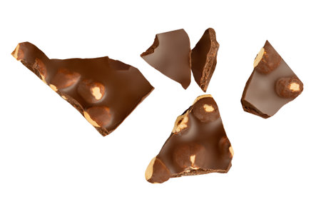 Chocolate with hazelnuts isolated on white. Explosion of Broken chocolate bar pieces with hazel nuts. Creative layout of Levitating chocolate chunks in the airの写真素材