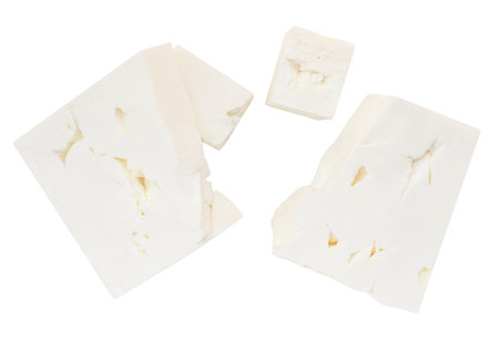 Feta cheese isolated. Greek fitaki cheese pieces on white background. Fresh soft cheese block Top view. Flat lay. Package design elementの写真素材