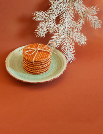 Dutch waffle called a stroopwafel on a yellow background on the plate with christmas tree.の写真素材