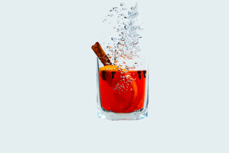 Mulled wine in a glass isolated in water on a white background. Red juice is under the water with bubbles.の写真素材