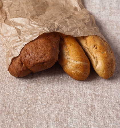 Different bread ciabatta without yeast. Fresh bread in paper on the canvas background. Healthy food concept.の写真素材