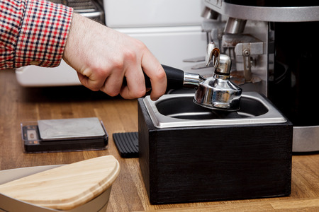 Young handsome barista hipster making coffee for his clients in the cafe.の写真素材