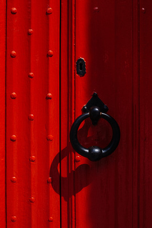 The red door with big black forged handle.の写真素材