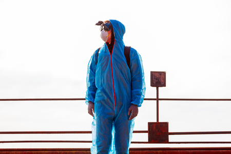 Men in blue protective overall at the old destroyed and lost factory. Concept of environmental polution and ecological catastrophe.の写真素材