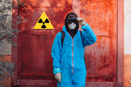 Men in blue protective overall near icon of radiation poisoning. Concept of environmental polution and ecological catastrophe.の写真素材