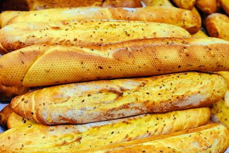 Different bread on the shelves in the bakery. Fresh baguette with corn in supermarket or batch.の写真素材