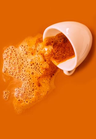 White cup of black coffee with foam on the orange background. Cappuccino background with smoke and one cup, copy space.の写真素材
