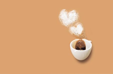 White cup of black coffee with foam as two hearts on the cappuccino background. Valentines day concept, copy space.の写真素材