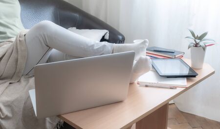 Woman uses the laptop. Close-up of the working place at home. The concept of good job online.の写真素材