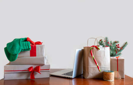 Table with Laptop, Packing bag, Gift's boxes and Christmas Tree. Online Delivery concept.の写真素材