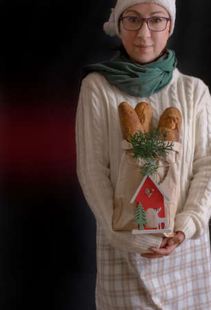 Woman holding Shopping Bag with Bread for holiday New Year or Christmas, Delivery concept.の写真素材