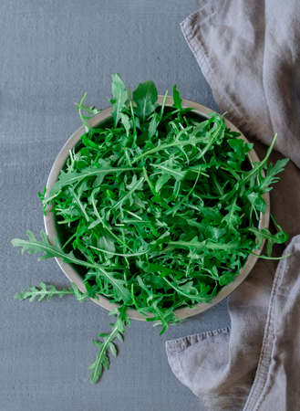Plate with fresh green arugula on gray backgroundの写真素材