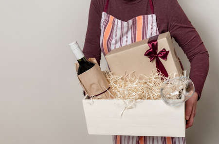 Worker of Delivery Service Packing Wine Bottle and Gifts to box with straw for Customer.の写真素材