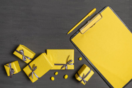 A Lot of Yellow Gifts Box and resume sheet on the Gray Color Background, top view.の写真素材