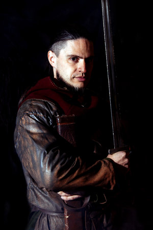 Viking forges weapons and swords in the smithy. A man in a warrior's clothes is in the smithyの写真素材