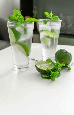 Cocktail Gin Tonic or Mojito in glass with mint, ice, lime on the white background.の写真素材