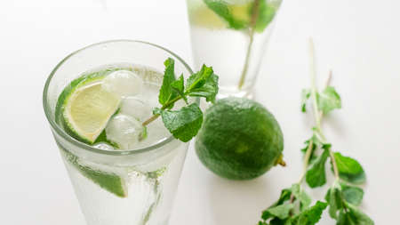 Cocktail Gin Tonic or Mojito in glass with mint, ice, lime on the white background.の写真素材