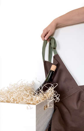 Straw into storage box, bottle wine and hand with brown apron on the white background, delivery service.の写真素材