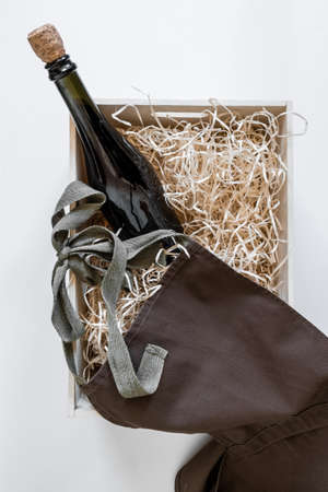 Straw into storage box, bottle wine and brown apron on the white background, delivery service.の写真素材
